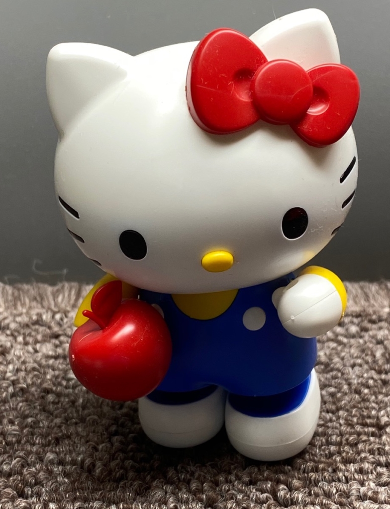 プラモのキティちゃんがリンゴをもって立っている